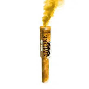 Fumigène à main jaune en activation, libérant une fumée dense et vibrante dans un espace extérieur.