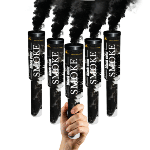 Fumigène à main noir en pleine activation, libérant une fumée dense et colorée dans un environnement extérieur.