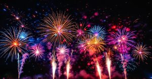 Cierges magiques allumés projetant des étincelles dorées lors d'une fête nocturne festive