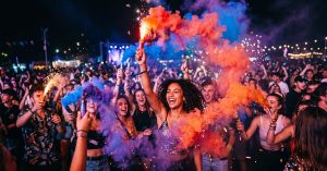 Fumigène à main coloré produisant une fumée vive rouge et bleue lors d'un événement festif nocturne