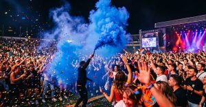 Fumigène bleu en action produisant une épaisse fumée colorée lors d'une célébration festive nocturne