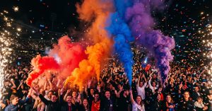 Fumigènes couleur blanc, rose, vert et violet en action lors d'un événement festif