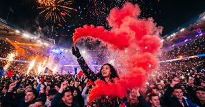 Fumigène rouge produisant une épaisse fumée colorée lors d'un événement festif nocturne
