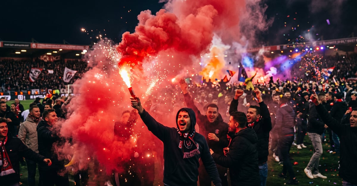 Fumigène rouge allumé produisant une épaisse fumée écarlate lors d'un événement festif nocturne